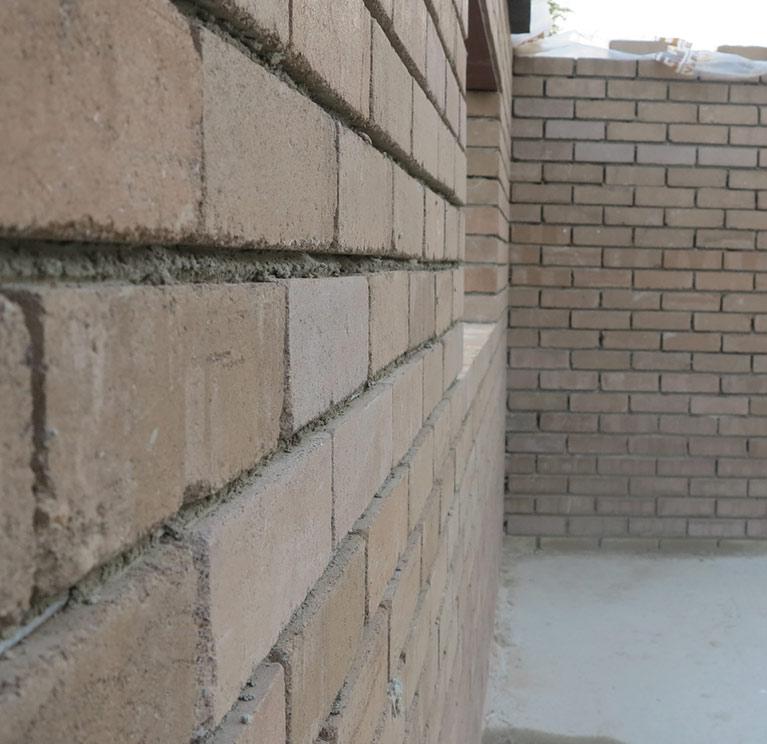 Réalisation de maçonneries en terre crue sur un chantier en écobioconstruction.